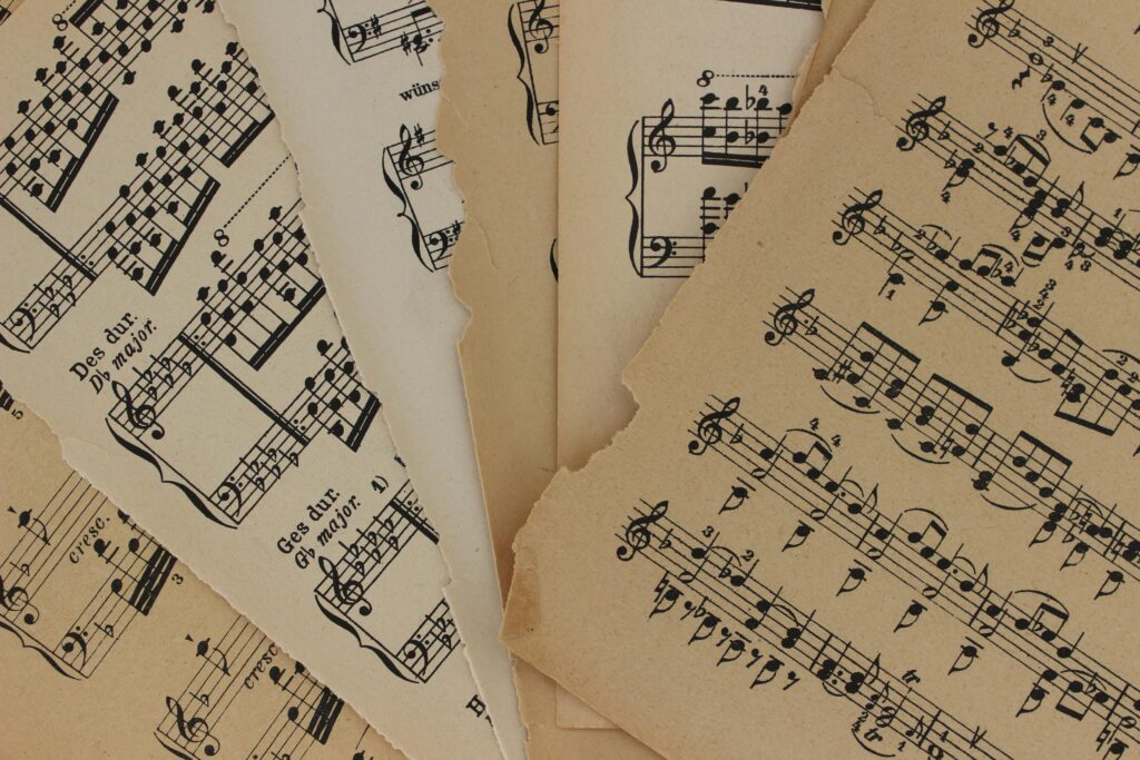 pexels-photo-4841308-4841308 Close-up of vintage sheet music with torn edges, highlighting musical notations and history.
